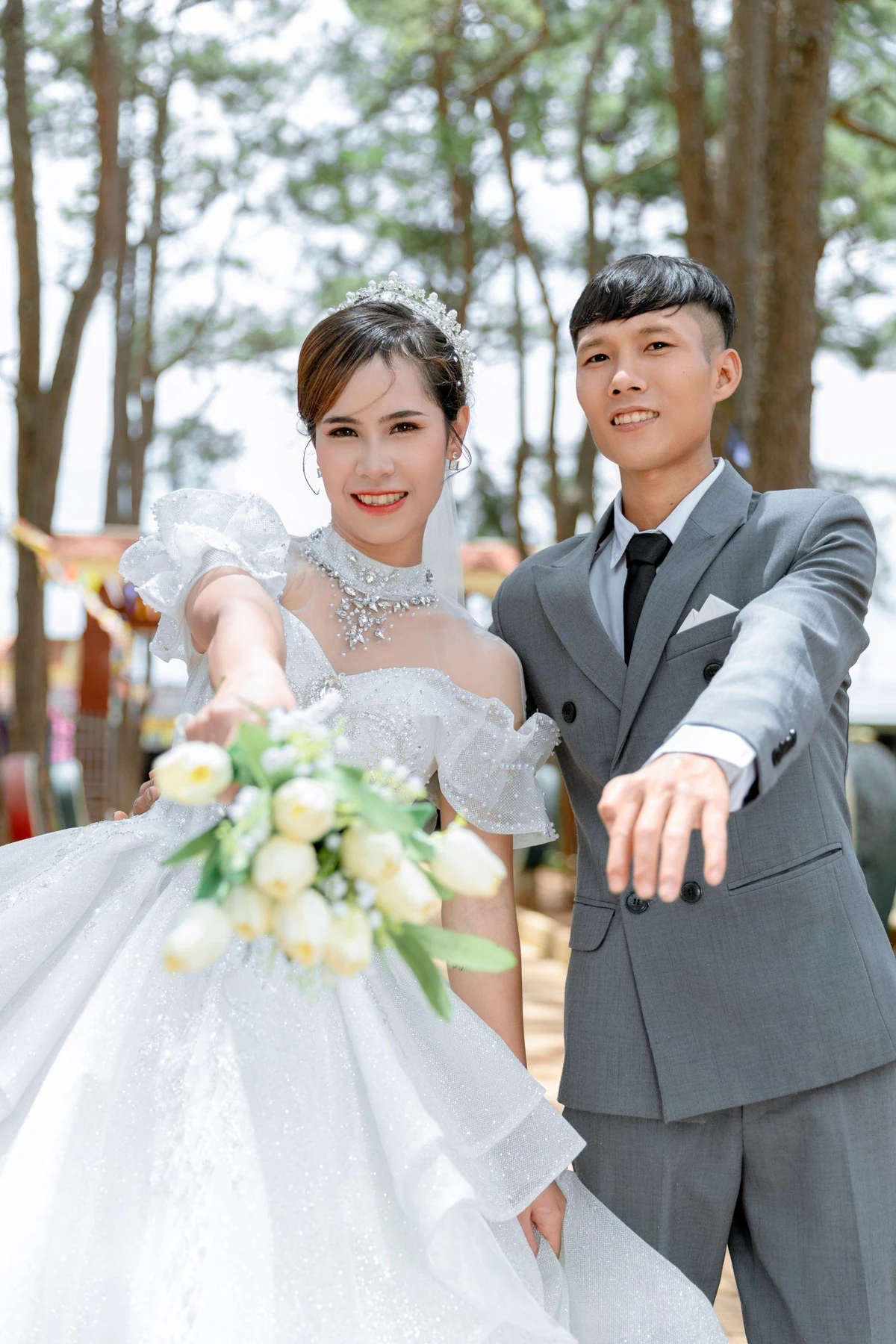 A wedding couple outdoors with their faces, hands and rings visible in the photograph.